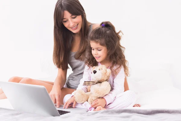 Mãe e filha felizes usando o laptop — Fotografia de Stock