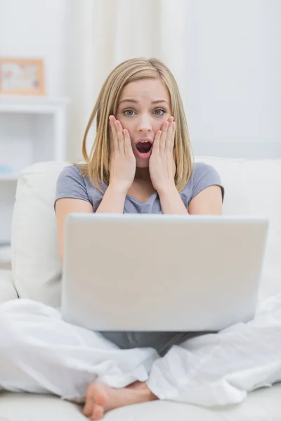 Portrait de femme décontractée choquée avec ordinateur portable à la maison — Photo