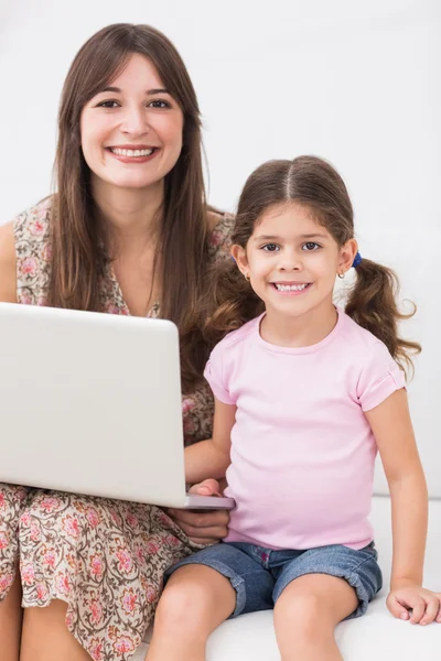 微笑母亲和女儿用的笔记本电脑 — 图库照片