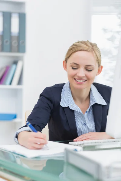 Mujer de negocios escribiendo notas en el escritorio de oficina —  Fotos de Stock