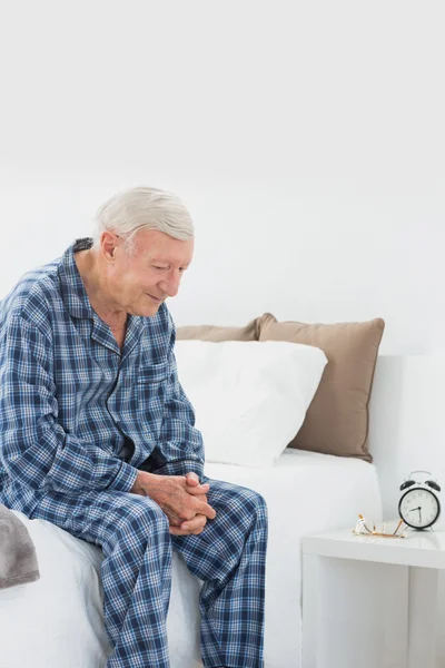 Ήρεμη ηλικιωμένος άνδρας κάθεται στο κρεβάτι — Φωτογραφία Αρχείου