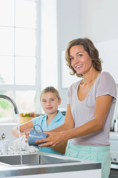 Mamma tvätt upp med dotter torkning — Stockfoto