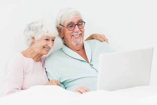 Paar benutzt Laptop im Bett — Stockfoto