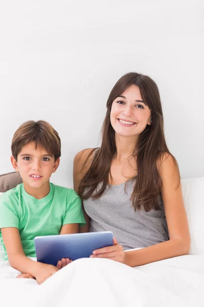 Sorrindo filho e mãe usando tablet — Fotografia de Stock