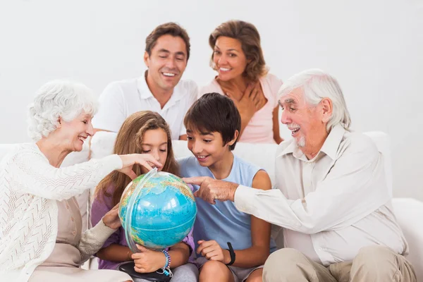 Família estendida olhando para globo — Fotografia de Stock