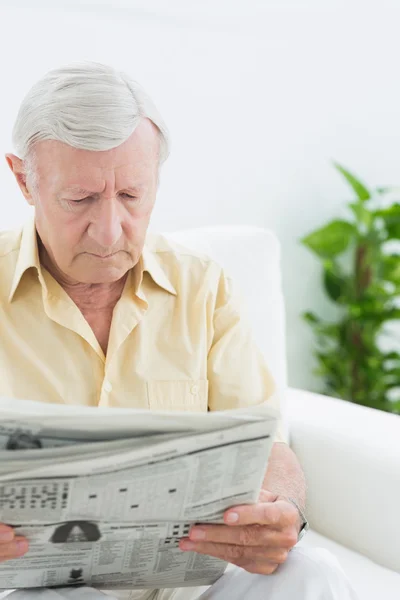 Älterer, konzentrierter Mann liest Zeitung — Stockfoto