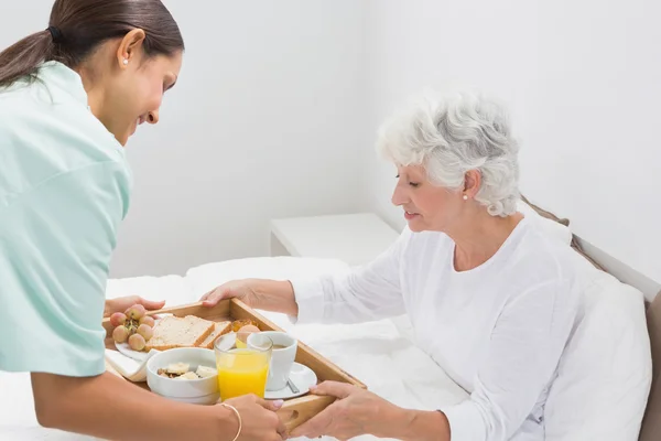 Ηλικιωμένη γυναίκα, λαμβάνοντας ένα πρωινό με σπίτι νοσοκόμα — Φωτογραφία Αρχείου
