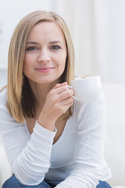 Retrato de mujer con taza de café sentado en el sofá — Foto de Stock