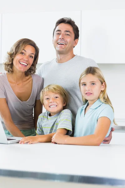 Familia alegre de pie en la cocina — Foto de Stock