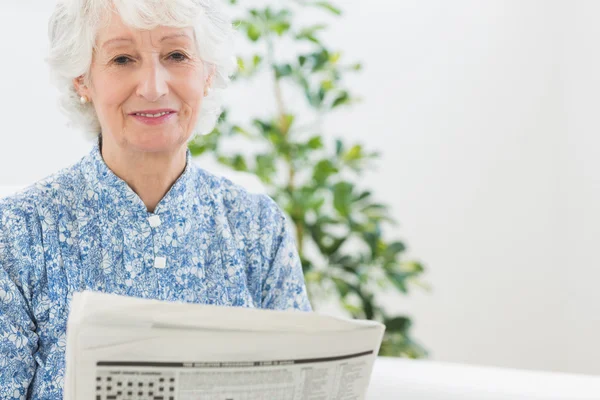 Äldre lugn kvinna läser tidningar — Stockfoto