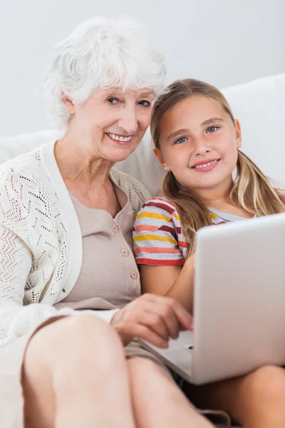 Ragazza felice utilizzando computer portatile con la nonna — Foto Stock