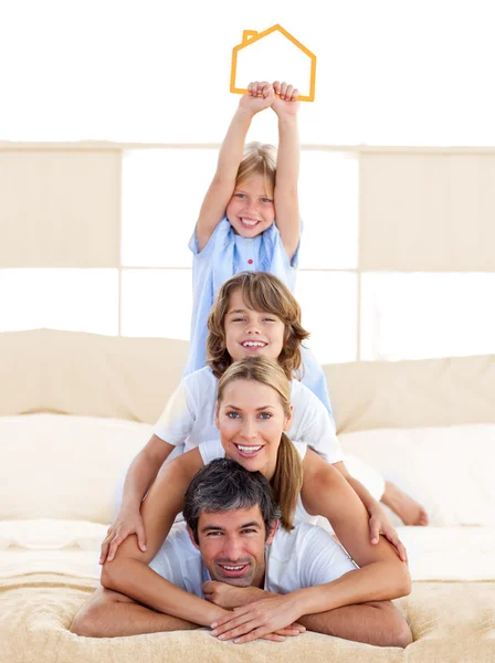 Jolly family having fun with yellow house illustration — Stock Photo, Image