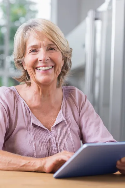 Mujer madura feliz usando su tableta digital —  Fotos de Stock