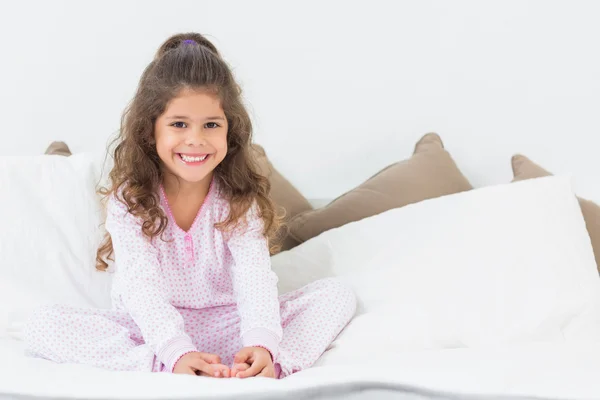 Roztomilá dívka sedící na posteli — Stock fotografie