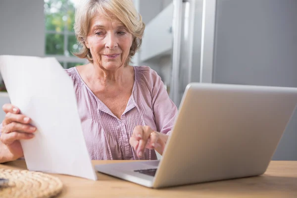 Stern mature woman using her laptop — Stock Photo, Image