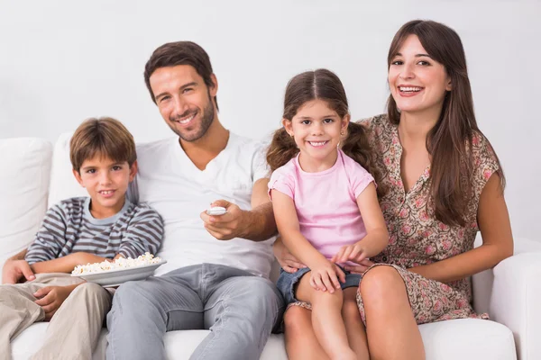 Leende familjen tittar på TV — Stockfoto