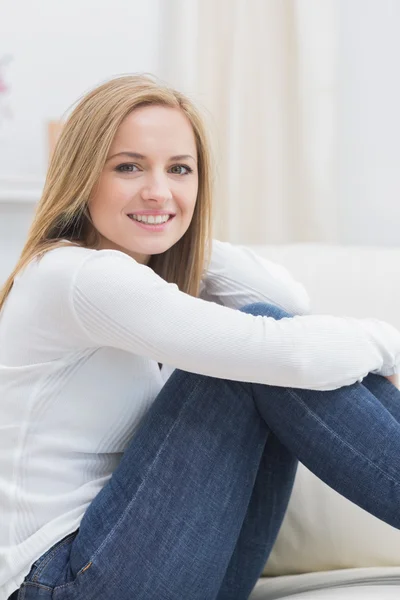 Portrait of casual happy woman sitting on sofa — Stock Photo, Image