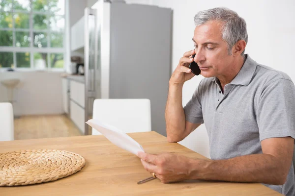 Uomo che chiama e legge un foglio di carta — Foto Stock