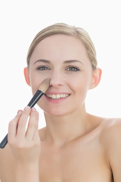 Porträtt av leende ung kvinna sätta på make-up — Stockfoto