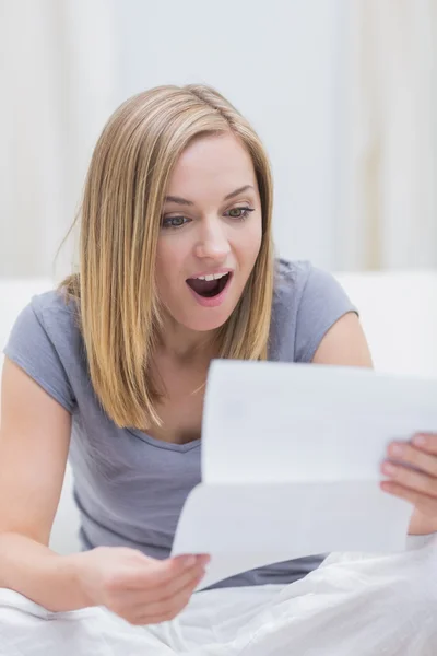 Mulher chocada ler carta na sala de estar — Fotografia de Stock