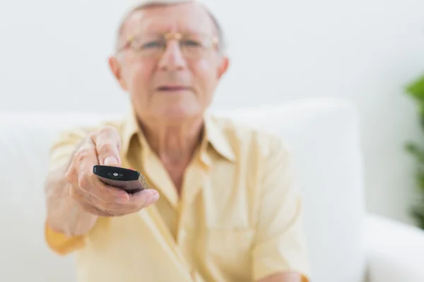 Homme âgé concentré utilisant la télécommande — Photo