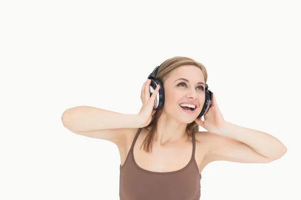 Jonge vrouw genieten van muziek via een hoofdtelefoon — Stockfoto