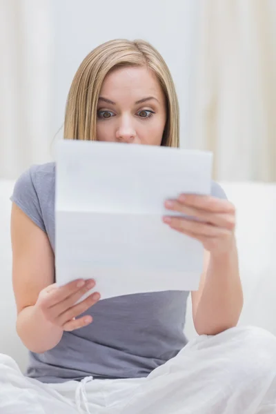 Casual woman reading letter in living room — Stock Photo, Image
