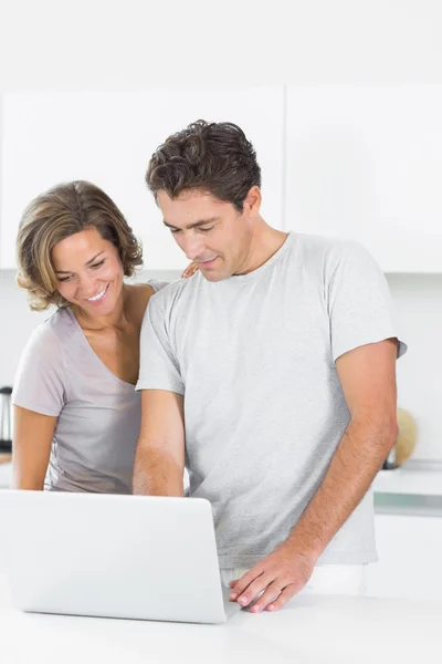 Sorrindo casal usando laptop juntos — Fotografia de Stock