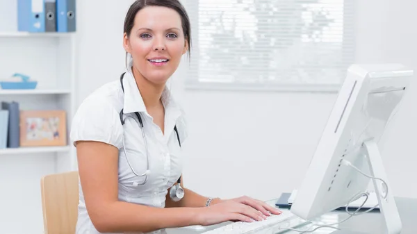 Doctora usando computadora en el escritorio de la clínica —  Fotos de Stock