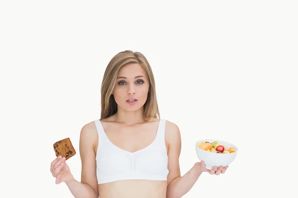 Porträt einer jungen Frau mit Keks und Obstschale — Stockfoto