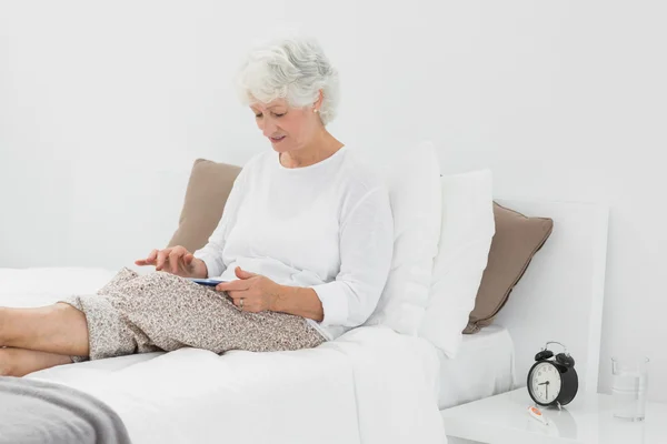 Elderly woman using a digital tablet — Stock Photo, Image