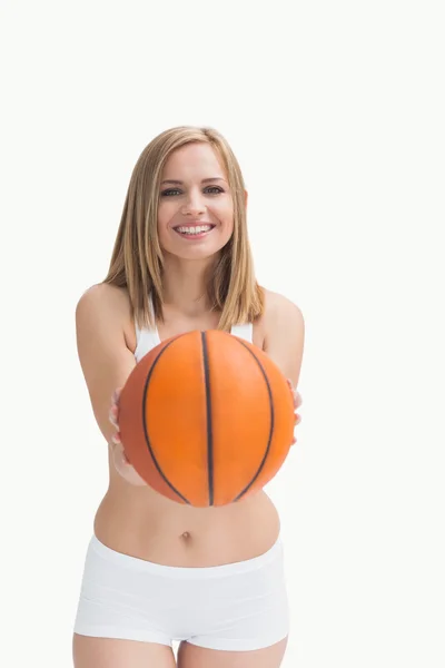 Felice donna in abbigliamento sportivo tenendo fuori il basket — Foto Stock