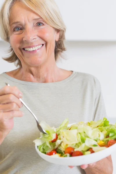 Feliz mujer madura comiendo ensalada — Foto de Stock