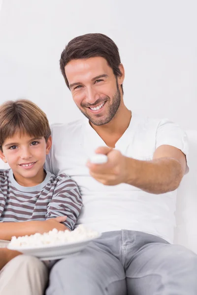 Smiling father and son watching tv — Stock Photo, Image