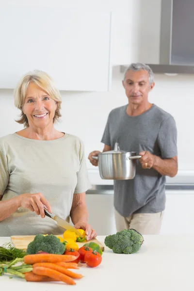 Муж приносит сковородку своей улыбающейся жене — стоковое фото