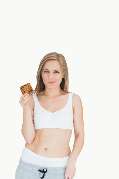 Portrait of young woman makes faces as holds cookie — Stock Photo, Image