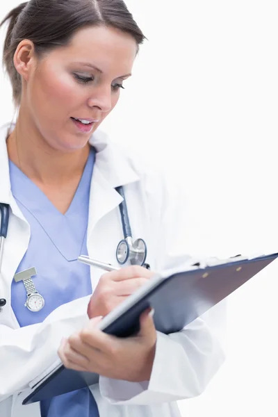 Médico feminino escrevendo na área de transferência — Fotografia de Stock