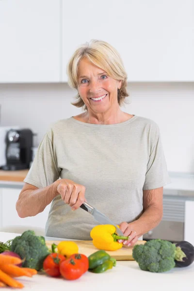 Mogen kvinna skära en gul paprika — Stockfoto