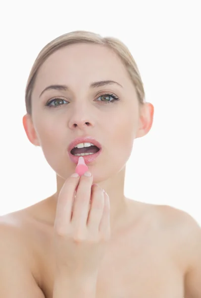 Close-up portrait of young woman applying lipgloss — Stock Photo, Image