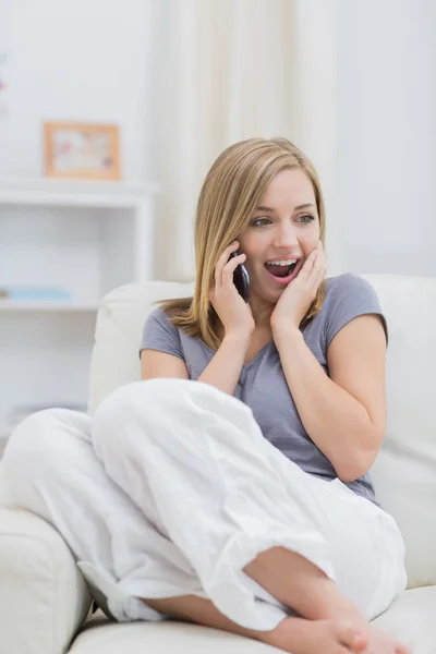 Casual surpreendido mulher usando celular em casa — Fotografia de Stock