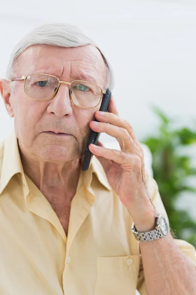 Olycklig äldre man på mobiltelefonen — Stockfoto