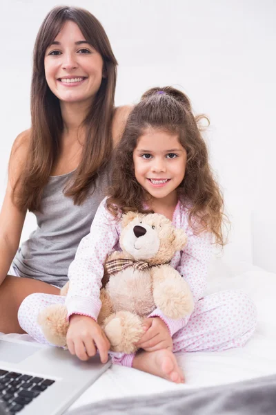 Sonriente hija y madre con portátil — Foto de Stock