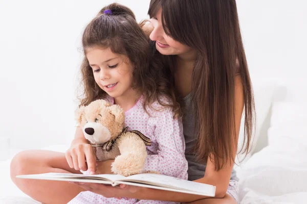 Mãe e filha lendo um livro de histórias — Fotografia de Stock