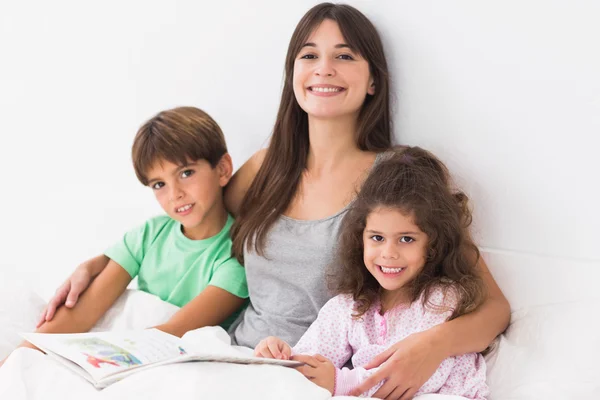 Mère avec ses enfants lisant un livre d'histoires — Photo