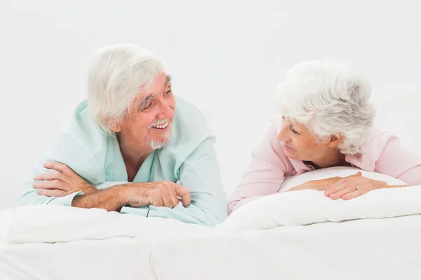 Happy couple looking at each other in bed — Stock Photo, Image