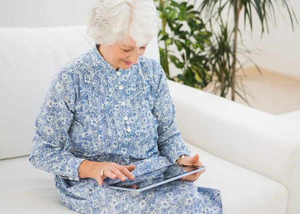 Yaşlı gülümseyen kadın dijital tablet kullanma — Stok fotoğraf