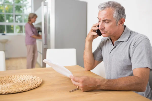 Man calling and reading a sheet of paper — Stock Photo, Image