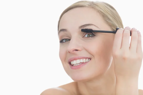 Close-up portrait of young woman applying mascara to her eye — Stock Photo, Image