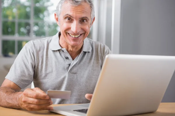 Sorridente uomo maturo utilizzando il suo computer portatile — Foto Stock