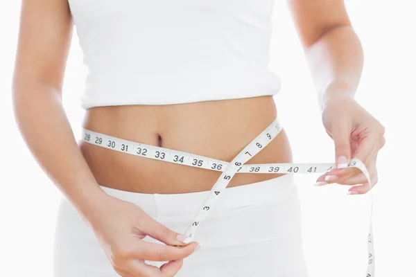 Midsection of woman measuring waist — Stock Photo, Image